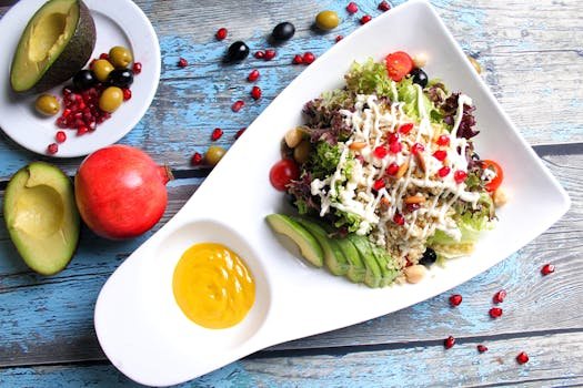 Colorful salad featuring avocado, pomegranate seeds, and fresh vegetables on a rustic table setting.